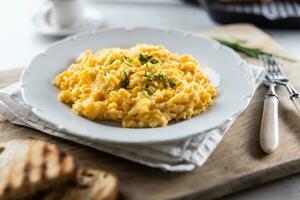 Appetizing breakfast full of proteins in a form of scrambled eggs in a plate photo