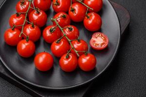 Delicious fresh cherry tomatoes on the branches as an ingredient for cooking a vegetarian dish photo