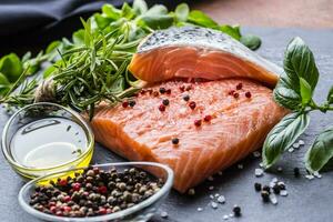 Raw salmon fillet with rosemary basil olive oil salt and pepper photo