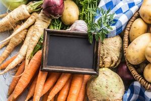 Fresh vegetables on the table with an empty blackboard photo