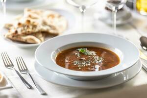 Italian vegetable minestrone soup with fresh herbs on top and pizza dough as a side dish photo