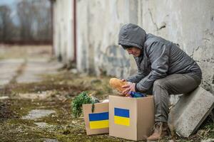 Vysne Nemecke, Slovakia. March 30. 2022. Older man takes bread out of box full of humanitarian aid for Ukraine in the war-torn area photo