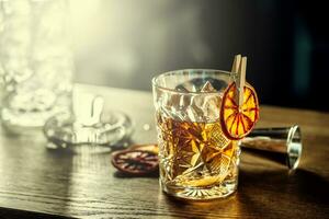 Old fashioned classic cocktail drink in crystal glass on bar counter photo