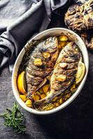 Roasted mediterranean fish bream with potatoes rosemary and lemon photo