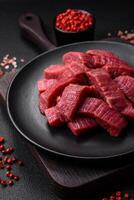 Juicy fresh raw beef meat with salt, spices and herbs photo