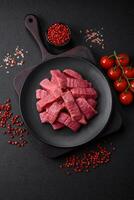 Juicy fresh raw beef meat with salt, spices and herbs photo