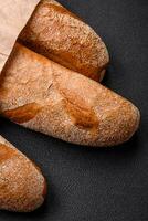 French baguette bread on a dark textured concrete background photo