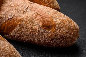 French baguette bread on a dark textured concrete background photo