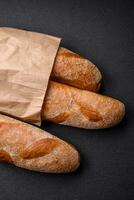 French baguette bread on a dark textured concrete background photo