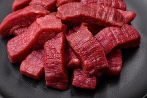 Juicy fresh raw beef meat with salt, spices and herbs photo