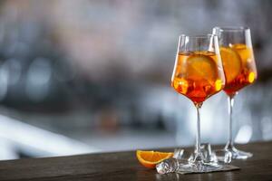 Typical summer sekt drink aperol spritz served in wine glass with aperol, prosecco, soda and a slice of orange photo