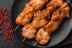 Delicious fresh, juicy chicken or pork kebab on skewers with salt and spices photo