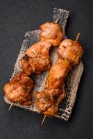 Delicious fresh, juicy chicken or pork kebab on skewers with salt and spices photo