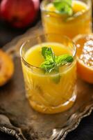 Two glasses with orange or multivitamin juice with mit herbs photo