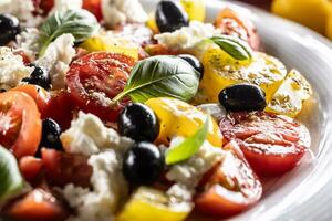 Caprese salad, mediterranean food, is served in white plate photo