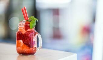 Strawberry non alcoholic lemonade with basil and ice cubes photo