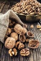 Walnut kernels whole walnuts in burlap sack and vintage bowl photo