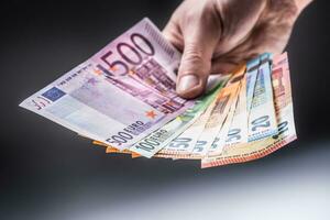 Male holding euro banknotes in his hands photo