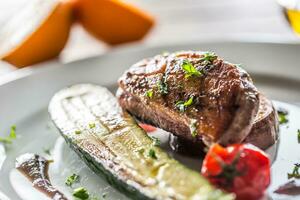 Roasted duck breast with zucchini tomato and parsley herbs photo