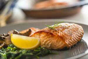 Salmon Roast Fillet. Portion of roast salmon fillet with spinach mushrooms in restaurant pub home or hotel photo