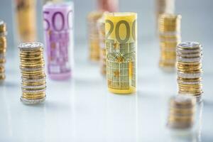 arrollado euro billetes y monedas torres apilado en otro posiciones foto