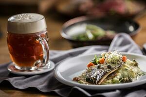 Baked trout fillet with mashed potatoes and draft beer photo