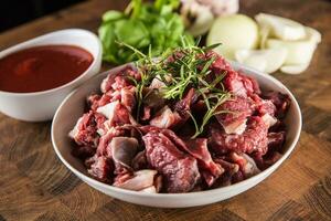 Sliced pieces of beef in plate with rosemary onion and garlic photo