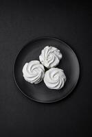 Delicious sweet colored marshmallow on a dark concrete background photo