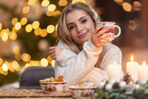 joven hermosa mujer en un Navidad atmósfera participación un taza con café o té foto
