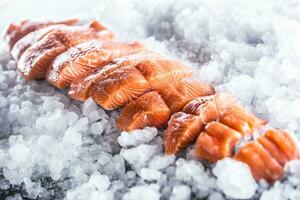 salmón filetes en porciones en hielo y vacío cocina tablero foto