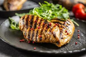 Chicken breast grilled with spices peper salt tomatoes and arugula photo