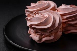 Delicious sweet colored marshmallow on a dark concrete background photo