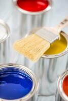 Close-up brush lying on multicolored paint cans. photo