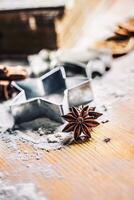 Star anise cookie cutter cinnamon and flour on baking board. Christmas baking utensil and holiday concept photo