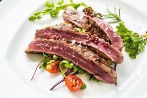 Close-up  juicy flank steak from vegetable salad. photo