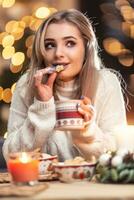 un hermosa joven rubia mujer sabores Fresco Navidad pan de jengibre con genial gusto foto
