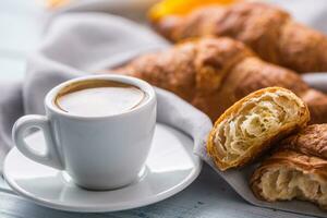 Fresh buttery croissants with coffee. Sweet morning breakfast concept. photo