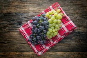 uva. manojo de multicolor uvas en rústico de madera mesa foto