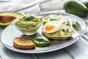 Toast bread with guacamole spread and egg. photo