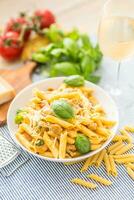 pasta pasta con pollo piezas hongos albahaca parmesano queso y blanco vino. italiano comida en blanco plato en cocina mesa foto