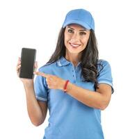 Attractive dark-haired woman smiling and pointing with her index finger at the mobile phone. wearing a blue uniform and red band over her wrist. Isolated background photo