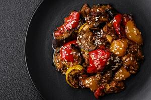 Delicious juicy fresh salad of baked eggplant, tomatoes, sweet peppers, sesame seeds photo