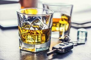 Car keys and glass of alcohol on table in pub or restaurant photo