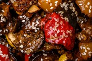 Delicious juicy fresh salad of baked eggplant, tomatoes, sweet peppers, sesame seeds photo