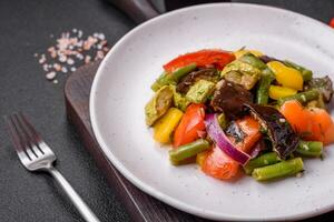 Delicious juicy fresh salad of baked eggplant, tomatoes, zucchini, onions photo