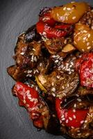 Delicious juicy fresh salad of baked eggplant, tomatoes, sweet peppers, sesame seeds photo