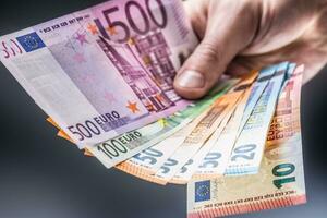 Male holding euro banknotes in his hands photo