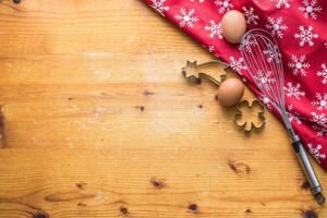 Christmas molds for baking with a whisk and a tablecloth with a Christmas motif - top of view photo