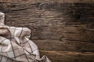 Top view of checkered tablecloth or napkin on empty wooden table photo