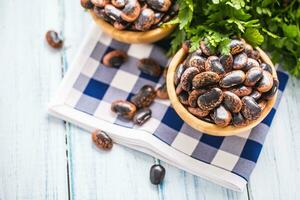 sin cocer frijoles en de madera bolos con perejil hierbas en cocina mesa foto